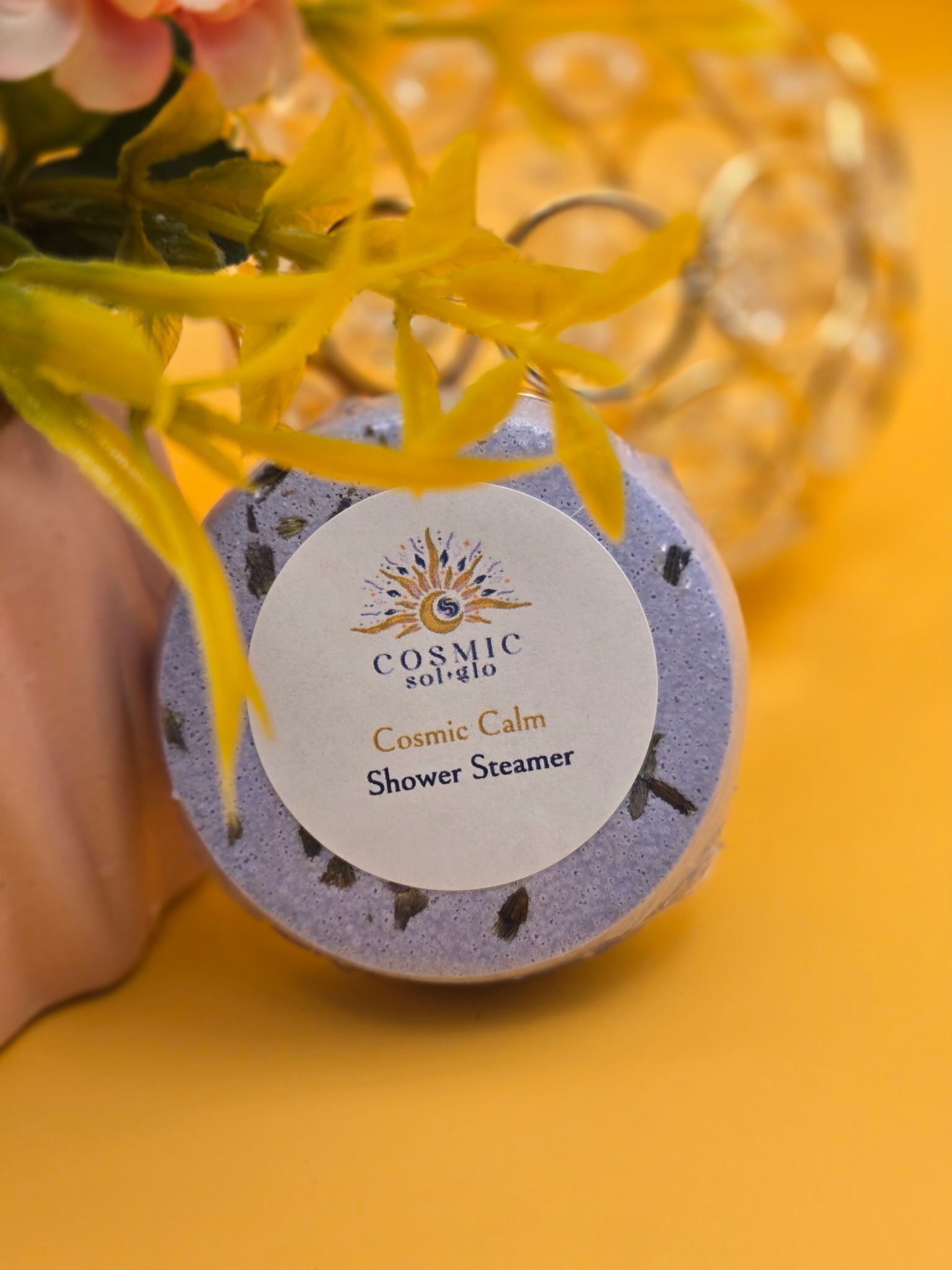 Cosmic Calm shower steamer flecked with lavender, labeled Cosmic Sol Glo