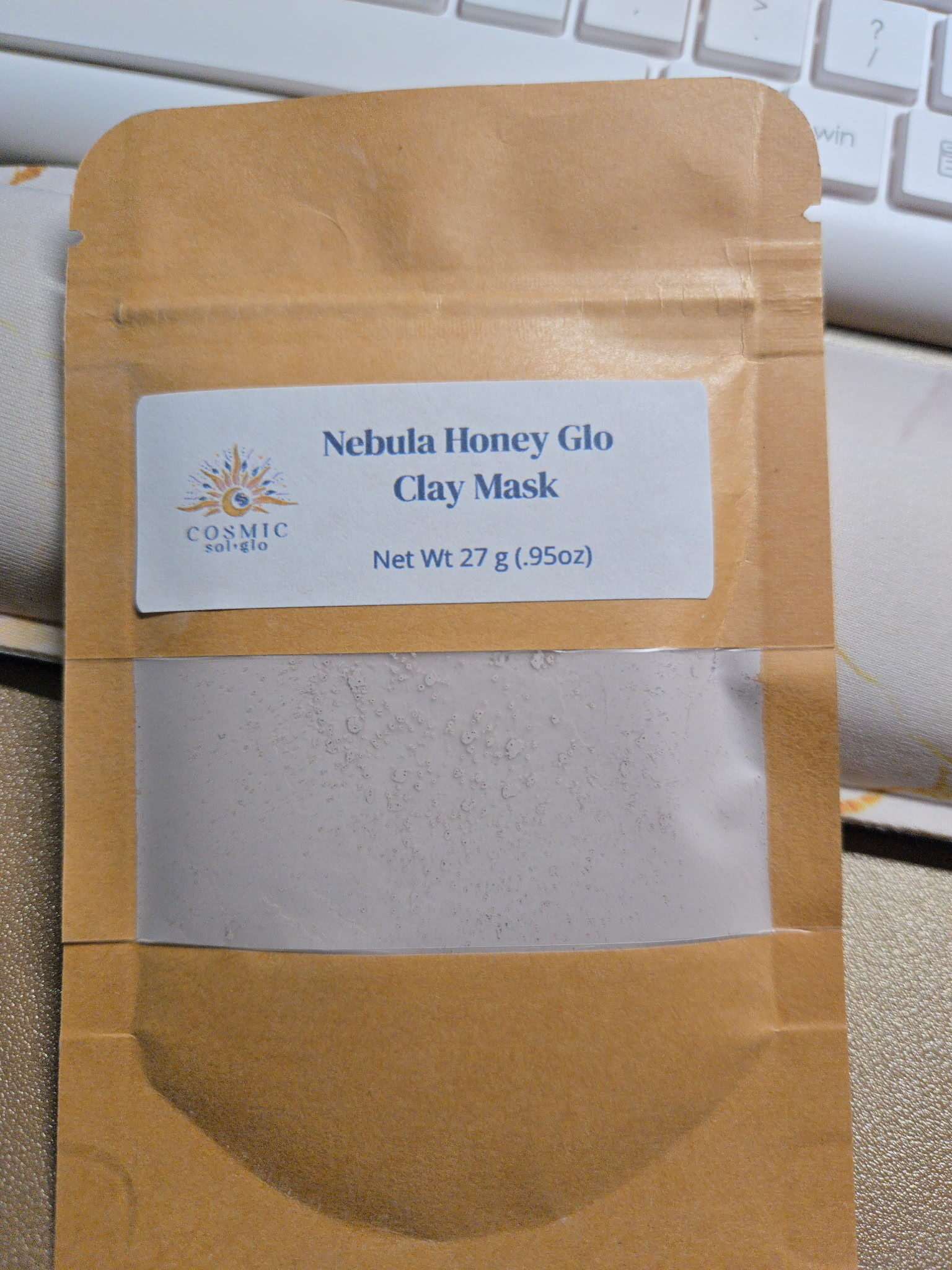 Nebula Honey Glo clay mask pouch flat on a desk, showing the powder through the window